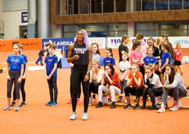 Priscilla Loomis speaking with young athletes